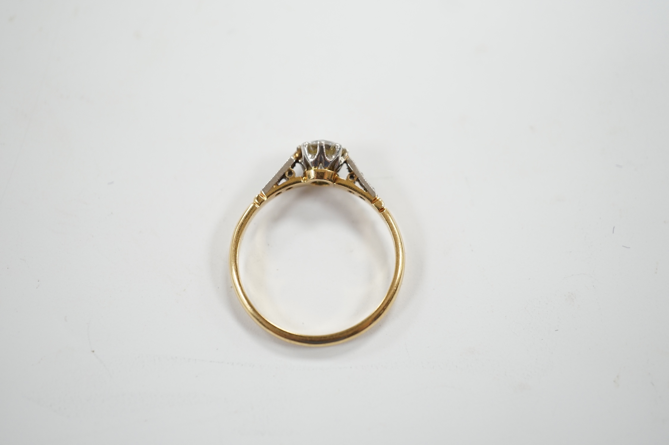 An early 20th century yellow metal and single stone diamond set ring, with diamond chip set shoulders, size N/O, gross weight 2.4 grams.